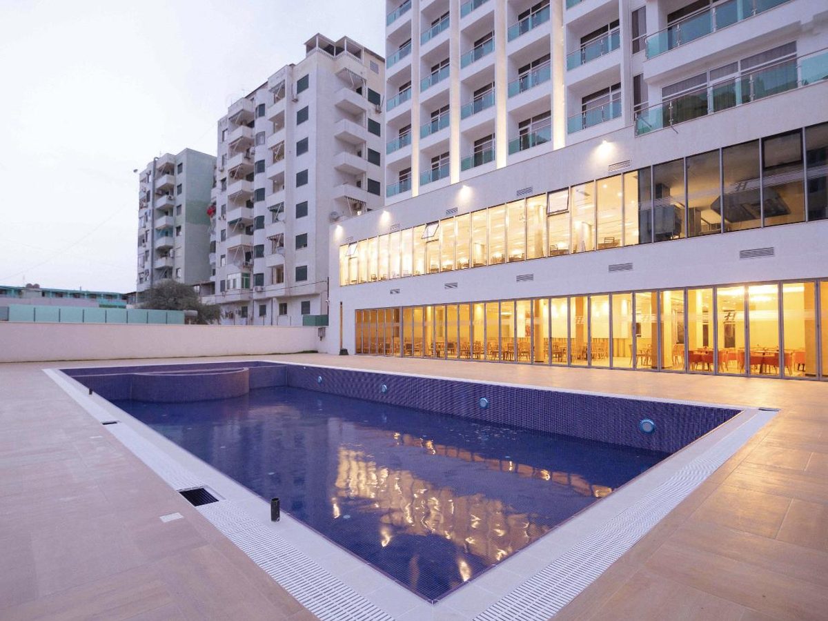 Hotel Horizont building and outdoor pool at dusk, Durrës